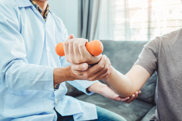 physiotherapist-man-giving-exercise-with-dumbbell-treatment-about-arm-shoulder_18497-1237